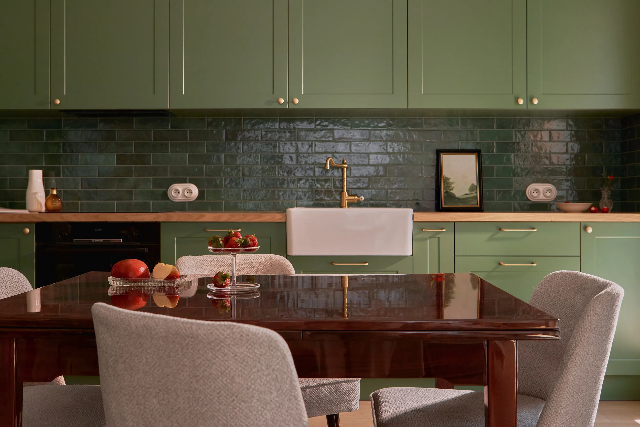 Sage green kitchen with butcher block counters and reeded glass cabinetry